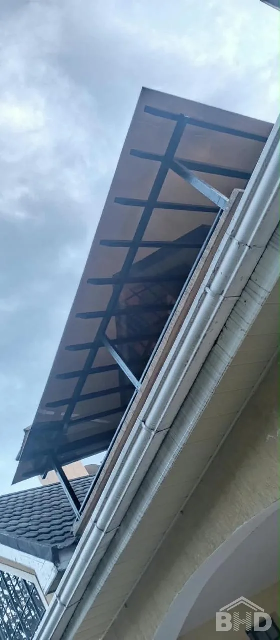 Bronze solid polycarbonate walkway canopy viewed from below, showing the steel support frame and fixings